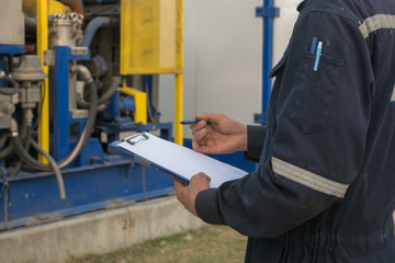 Worker engineer Man work in oil or gas refinery, turning on and off the pipeline valve torso and hand engineer yellow helmet .