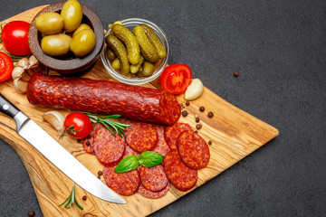 Dried organic salami sausage or chorizo on wooden cutting board