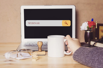 muslim woman drinking a coffee and searching webinar in search bar