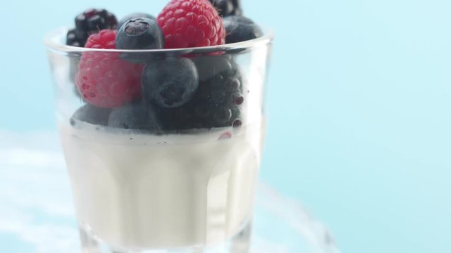tilttedvideo of glass with vanilla mousse desert or greek yougurt with raspberry blueberry and blackberry Minimalism food video
