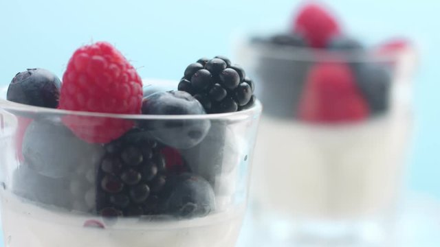 panned movement showing two glasses with yougurt and berries Minimalism food video