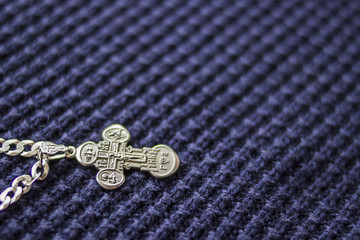 Silver cross on a blue background. Symbol of faith. Christianity