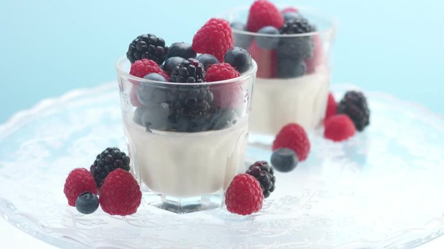 a sort of healthy breakfast with yougurt and berries in studio minimalist clip on blue background