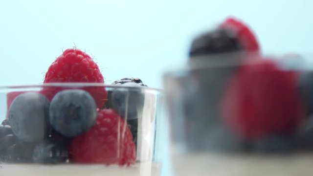 closeup of berries decoration of dessert in transparent glass full of panna cotta or greek yogurt