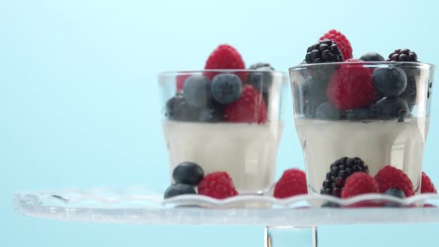 a sort of healthy breakfast with yougurt and berries in studio minimalist clip on blue background