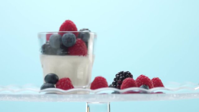 woman hand picked up one of two glasses with light dessert with berries