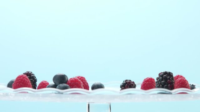 woman hand picked up one glasses with light dessert with berries