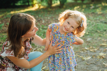 Mother hugging her cute smiling little daughter. Happy parenting