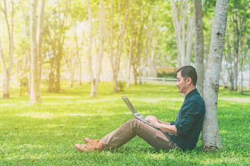 Obraz premium Happy asian young businessman with laptop celebrating success.
