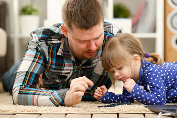 Cute little girl on floor carpet with dad