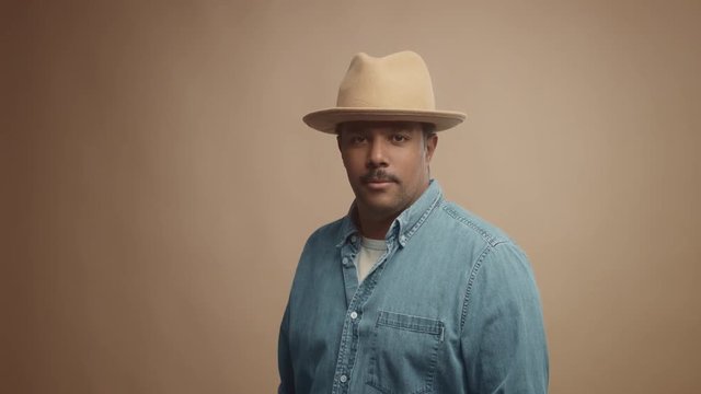 mixed race black man on beige background in studio portrait Colorfull clothes lineal dolly zoom