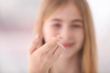 Teenage girl with contact lens on blurred background
