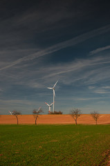 Obraz na płótnie Canvas Wind turbine on a field in spring with blue sky
