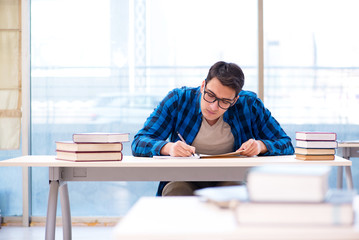Student studying in the empty library with book preparing for ex