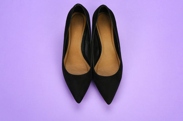 Stylish female shoes on color background