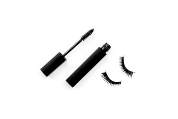 Basic products for eyelashes makeup. Mascara and false eyelashes on white background top view copy space