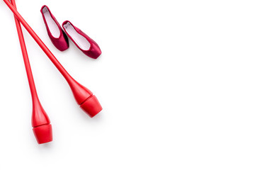 Beauty sport for girls concept. Maces for rhythmic gymnastics and ballet shoes on white background top view copy space
