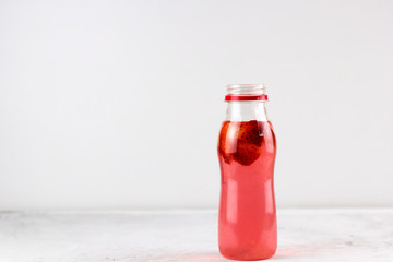 strawberry beverage bottle light background copy space