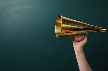 Woman holding retro megaphone near chalkboard