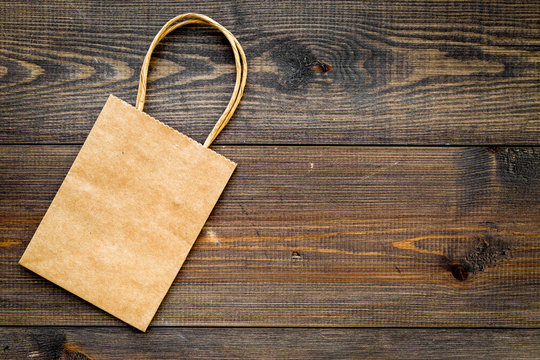 Brown kraft paper bag for shopping on wooden background top view copy space