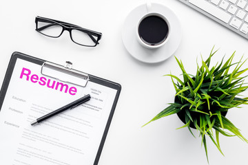 Create resume. Resume on white work desk with coffee, glasses, keyboard top view