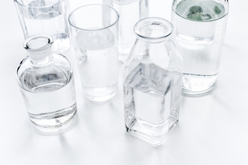 Drinks on the table. Pure water in jar and glasses on white background