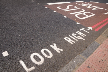 An inscription for pedestrians Look Right on the asphalt on the road with a left-hand traffic. London, UK.