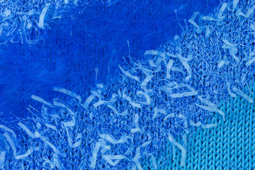 knitted fabric background in blue yarn of cotton, acrylic and angora