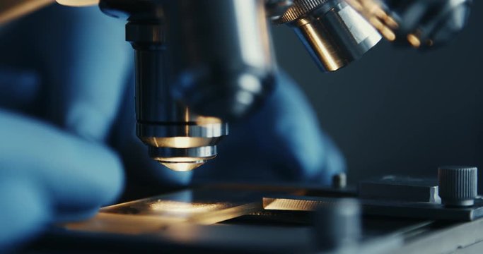 Scientist hands with microscope close-up shot in the laboratory