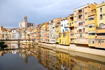 Colorful houses, reflected in the water of the river Onyar. View from the Red iron bridge or Girona Eiffel Bridge (Pont de les Peixateries velles). The historic Jewish quarter in Girona, Spain. 
