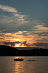 Family fishing on a boat on Ontario lake at sunset