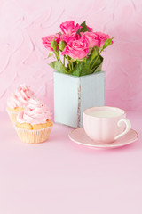 Pink pastel vertical banner with decorated cupcakes, cup of coffe with milk and bouquet of pink roses.