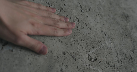 handheld of man hand touching concrete wall