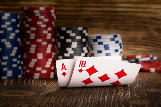two cards and poker chips on wooden background