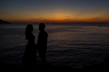 silhouettes of a couple holding hands at sunrise