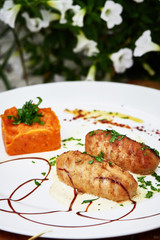 Delicious menu dish meat cutlet with carrot pie on white plate and wooden table