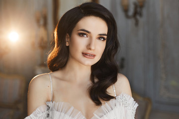 Fototapeta premium Portrait of beautiful young brunette woman in white lace dress