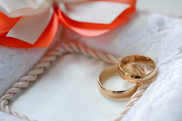 Wedding rings on a cushion decorated with ribbons and embroidery. Wedding day.