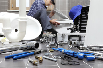 plumber at work in a bathroom, plumbing repair service, assemble and install concept