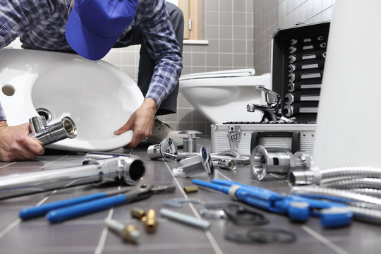 plumber at work in a bathroom, plumbing repair service, assemble and install concept