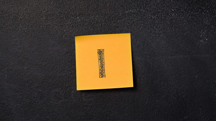 Sticky note with letter "I" on the blackboard