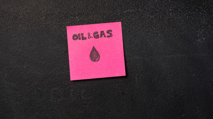 Sticky note with Oil and Gas words on the blackboard