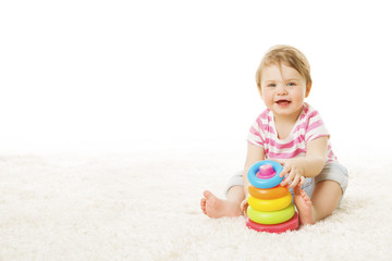 Baby Play Toy Rings Pyramid, Infant Kid Playing Building Blocks, one year Child Sitting on Carpet over White Background