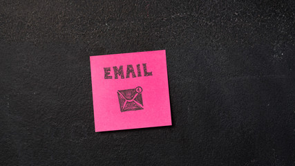 Sticky note with Email word on the blackboard