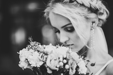 Portrait of attractive bride with wedding bouquet. Black and white photo.