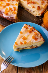 One of the options for a delicious dessert is cheesecake. Polish Cracow cheese cake. Appetizing syrnik with dried fruits and oranges. A treat for children and adults in warm orange tones.