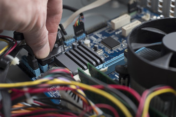 the hand of a computer engineer connect the cable, close-up