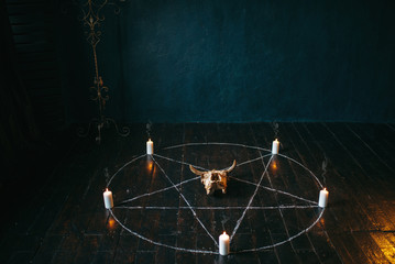 Pentagram circle with candles on wooden floor