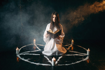 Woman sitting in the center of pentagram circle