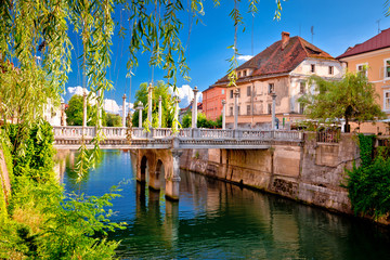 Green Ljubljanica riverfront and bridge in Ljubljana